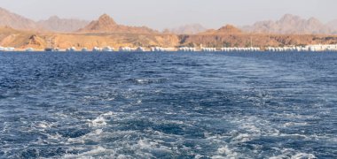 Dalgalı bir tekne dalgası. Deniz dalgası. Yat yelken açıyor, arkasında iz ve dalgalar bırakıyor..