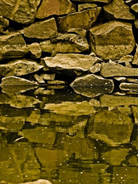 Reflection of stones in calm water