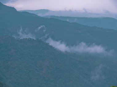 Monsoon rain clouds and mist, over hills and forest range during rainy season, Western Ghat, Maharashtra, India