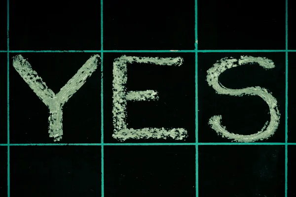 Yes word handwritten on black chalkboard — Stock Photo, Image