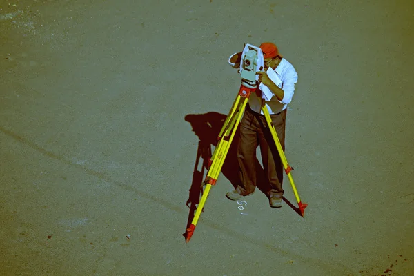 A surveyor at work with an infrared reflector used for distance — Stock Photo, Image