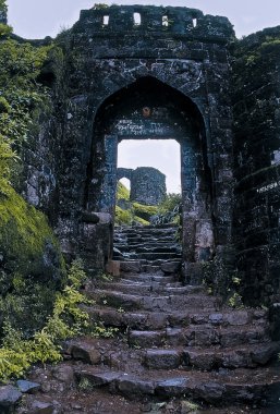 Steps leading towards an Entrance arch (Pune Darwaja) constructed in stone at Sihangad fort. Sinhangad, Pune, maharashtra, India.