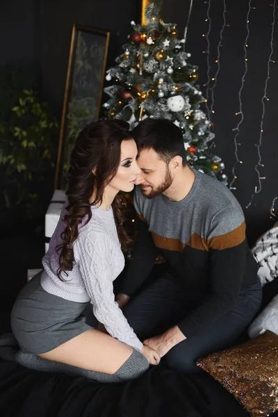 Beau homme et jeune beauté dans une tenue élégante passer la soirée de Noël ensemble dans un intérieur confortable — Photo