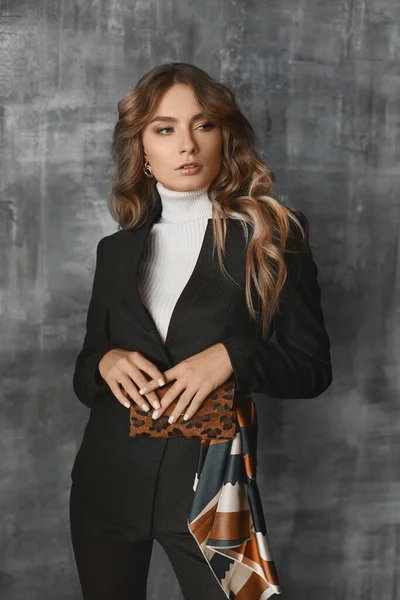 Leopar desenli kemer çantalı şık takım elbiseli güzel iş kadınının resmi. Ofiste gri duvara poz veriyor. — Stok fotoğraf