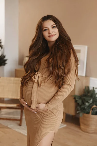 Retrato de uma bela mulher grávida com maquiagem suave, cabelos longos e em um vestido — Fotografia de Stock
