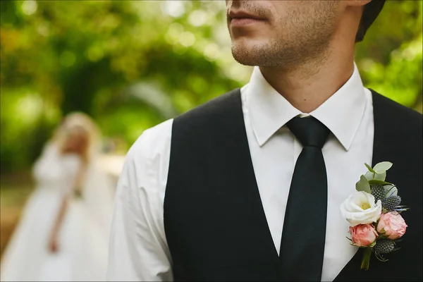 Zastřižený portrét nepoznatelného pohledného muže v černé kravatě a elegantní vestě s boutonniere. Stylový ženich čeká na nevěstu — Stock fotografie