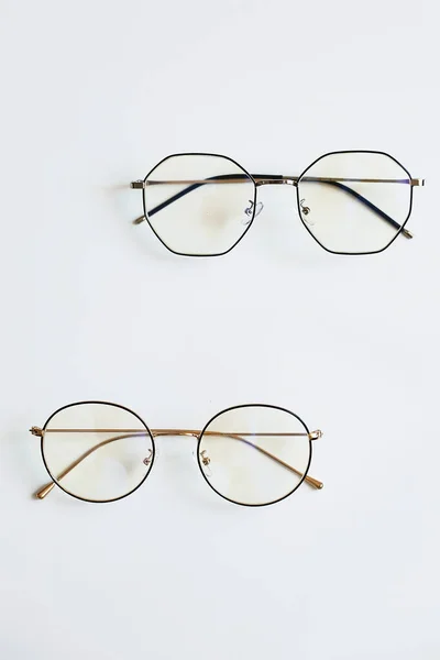Des lunettes unisexes élégantes à la mode sur fond blanc. Photo publicitaire des lunettes en métal. Concept optique de mode. Uniquement verres rétro à fond blanc — Photo