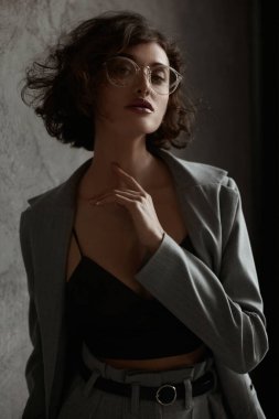 Siyah saten bir Cami bluzla gözlük takan kadın modelin yüksek moda portresi.