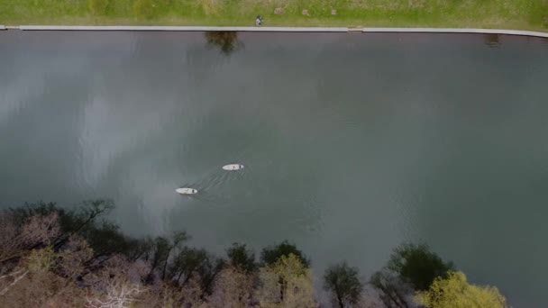 Imágenes aéreas de aviones no tripulados de dos personas en los jabalíes en el río de la ciudad en el día de primavera — Vídeos de Stock