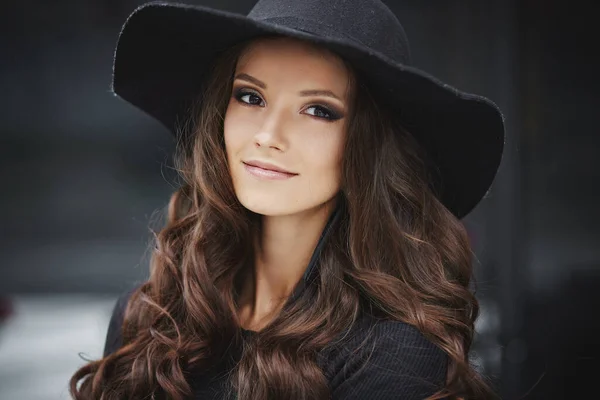 Closeup retrato de moda de uma jovem mulher modelo com maquiagem na moda vestindo chapéu preto na moda posando ao ar livre — Fotografia de Stock