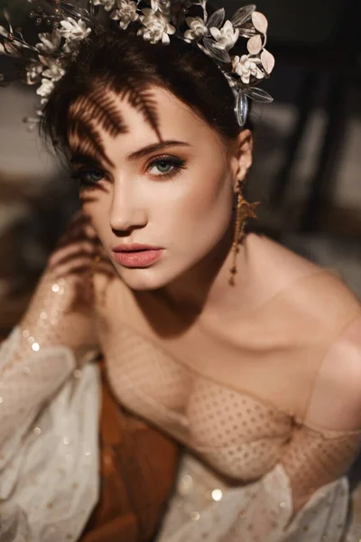 Όμορφο κορίτσι μοντέλο με τέλειο μακιγιάζ και κομψή διακόσμηση στα μαλλιά της. Πορτραίτο υψηλής μόδας μιας νεαρής γυναίκας με νυφικό μακιγιάζ και floral διακόσμηση στο νυφικό της ένδυμα — Φωτογραφία Αρχείου