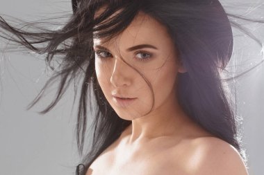 Moda portresi. Çıplak makyajlı, dalgalı saçlı, modaya uygun siyah şapkalı bir kadın.