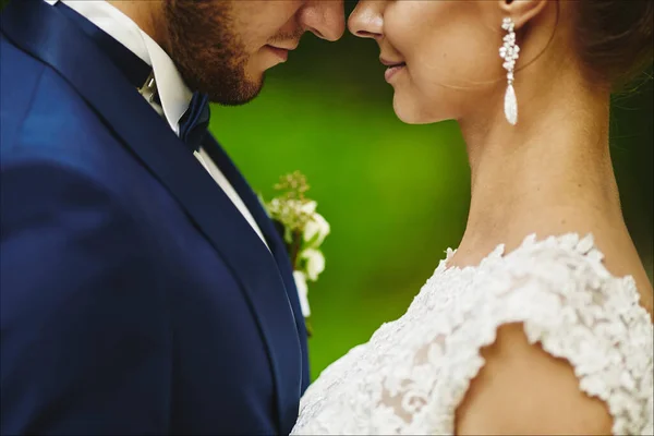 Marié Modish embrassant mariée magnifique pendant la cérémonie de mariage. Un couple aimant, une femme en robe de mariée et un bel homme en costume bleu élégant — Photo