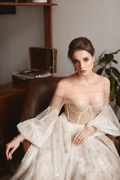 Красивая женщина модель в винтажном свадебном платье с длинными рукавами в помещении. Стильная молодая невеста в модном винтажном платье позирует в интерьере — стоковое фото