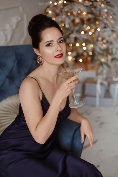 Μοντέλο γυναίκα με ένα ποτήρι σαμπάνια στο πάρτι της Πρωτοχρονιάς, πίνοντας σαμπάνια πάνω από εορταστικά φώτα εορτασμού φόντο. Ομορφιά γυναίκα με τέλειο μακιγιάζ μόδας — Φωτογραφία Αρχείου