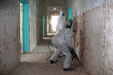 Koruyucu giysiler içindeki eski binaların yenilenmesinde çalışan işçiler