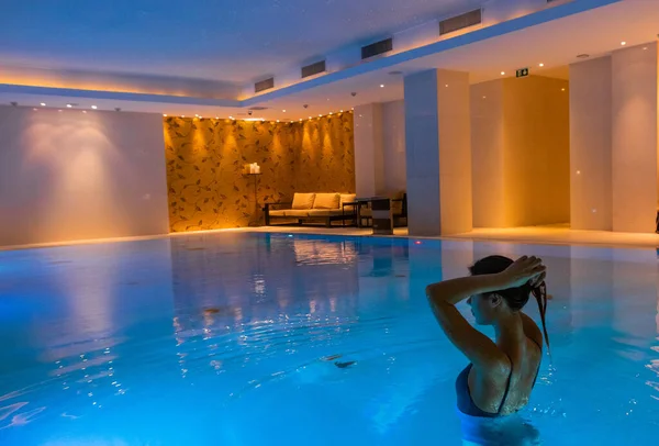 girl back in the pool indoor beautiful backlight and blue clear wate