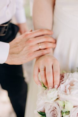 Gelinin ve damadın elleri bir arada Şefkatli bir çift düğün hikayesinde