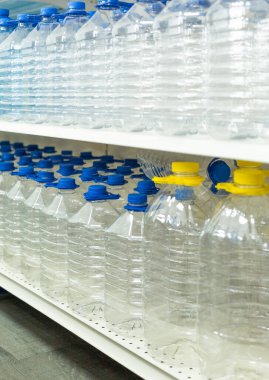 Su için bir sürü şişe kapaklı ve saplı vitrinde bir sırada duruyor.