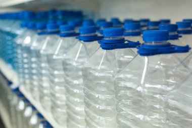 Su için bir sürü şişe kapaklı ve saplı vitrinde bir sırada duruyor.