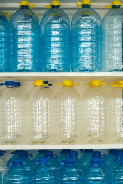 Su için bir sürü şişe kapaklı ve saplı vitrinde bir sırada duruyor.