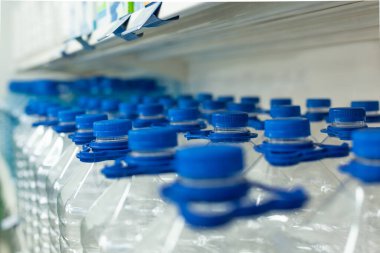 Su için bir sürü şişe kapaklı ve saplı vitrinde bir sırada duruyor.