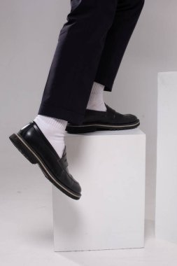 Moda adamı bacakları sıska kısa pantolon çoraplar ve beyaz kübün üzerindeki ayakkabılar