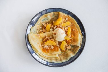 Reçelli gözleme ve bir kepçe dondurma ve taze portakal dilimleri.