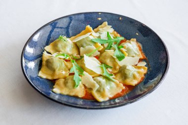 Hamur köftesi, roka ve sauc ile süslenmiş et yemeği.