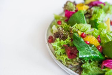 Taze sebze, ıspanak, avokado, portakal ve nar dilimleyen salata.