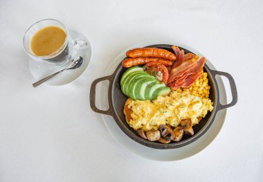 Yumurtalı omlet, sosis, et ve sebzeli salatalık domates ve kahve.
