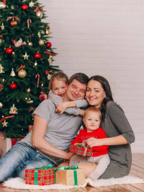 Aile Noel ağacının yanında Parlak bir hediyeyle