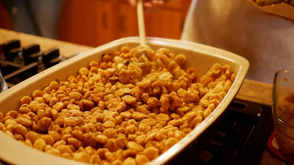 Adam Aile Yemeği sırasında tepsiden istiridye pişiriyor.