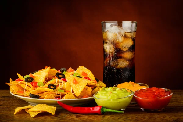 Assiette de nachos, trempette et boisson au cola — Photo