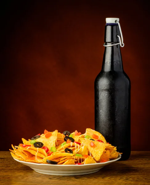 Chips tortilla et bouteille de bière — Photo