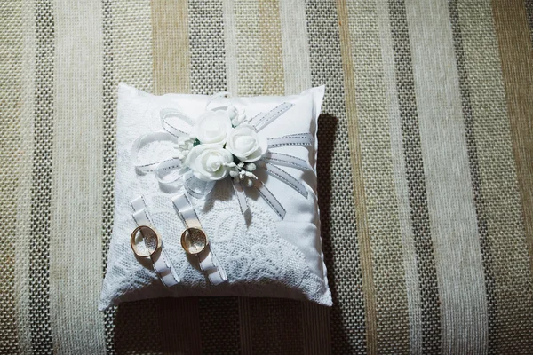 Anillos de oro de boda en almohada de regalo blanco —  Fotos de Stock