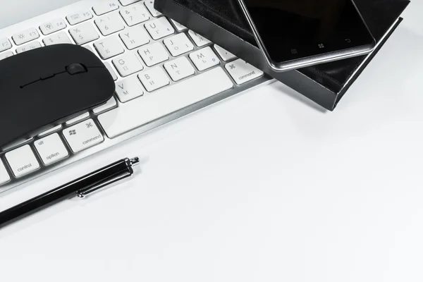 Blocco note, tastiera e cellulare su sfondo bianco — Foto Stock