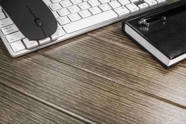Kladblok, toetsenbord, muis en cellphone op houten tafel — Stockfoto