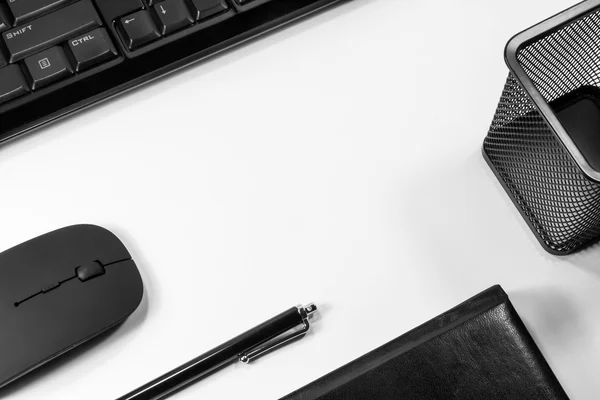 Ноутбук с ручкой, телефоном и компьютером на белой спинке — стоковое фото