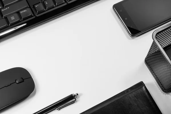 Laptop met een pen, een telefoon en een computer op een witte pagina Stockfoto