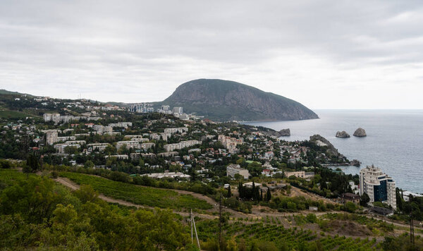 Панорамный вид на город Гурзуф, гору Медведь и море в Республике Крым, Россия. Облачный день 19 сентября 2020 г. Стоковое Фото
