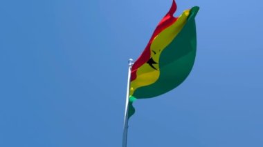 Gana 'nın ulusal bayrağı mavi gökyüzüne karşı rüzgarda dalgalanıyor.