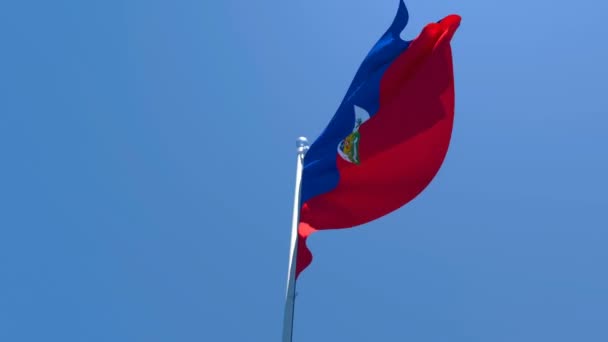 A bandeira nacional do Haiti está voando no vento contra um céu azul — Vídeo de Stock