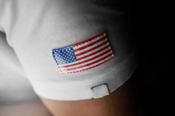 Patch of the national flag of the United States of America on a white t-shirt