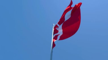 Danimarka bayrağı mavi gökyüzüne karşı rüzgarda dalgalanıyor.