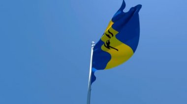 Barbados 'un ulusal bayrağı mavi gökyüzüne karşı rüzgarda dalgalanıyor.