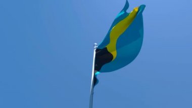 Bahama adalarının ulusal bayrağı mavi gökyüzüne karşı rüzgarda dalgalanıyor.