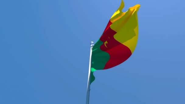 La bandera nacional de Camerún ondea en el viento contra un cielo azul — Vídeo de stock