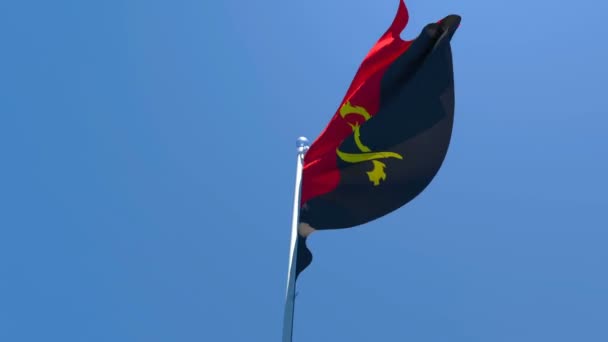 Flaga narodowa Angoli wisi na wietrze przeciwko błękitnemu niebu — Wideo stockowe