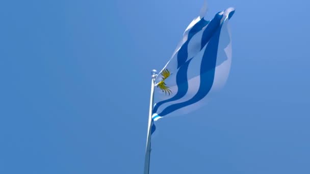 A bandeira nacional do Uruguai agita-se no vento contra um céu azul — Vídeo de Stock